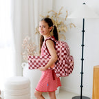 young girl modelling fit of Fox & Fallow backpack for kids, perfect for school, daycare and everyday use. Spacious, practical and designed for little adventures. Personalisation of embroidery with name also available on bags in 2 placements. This print is cherry check with matching pencil case
