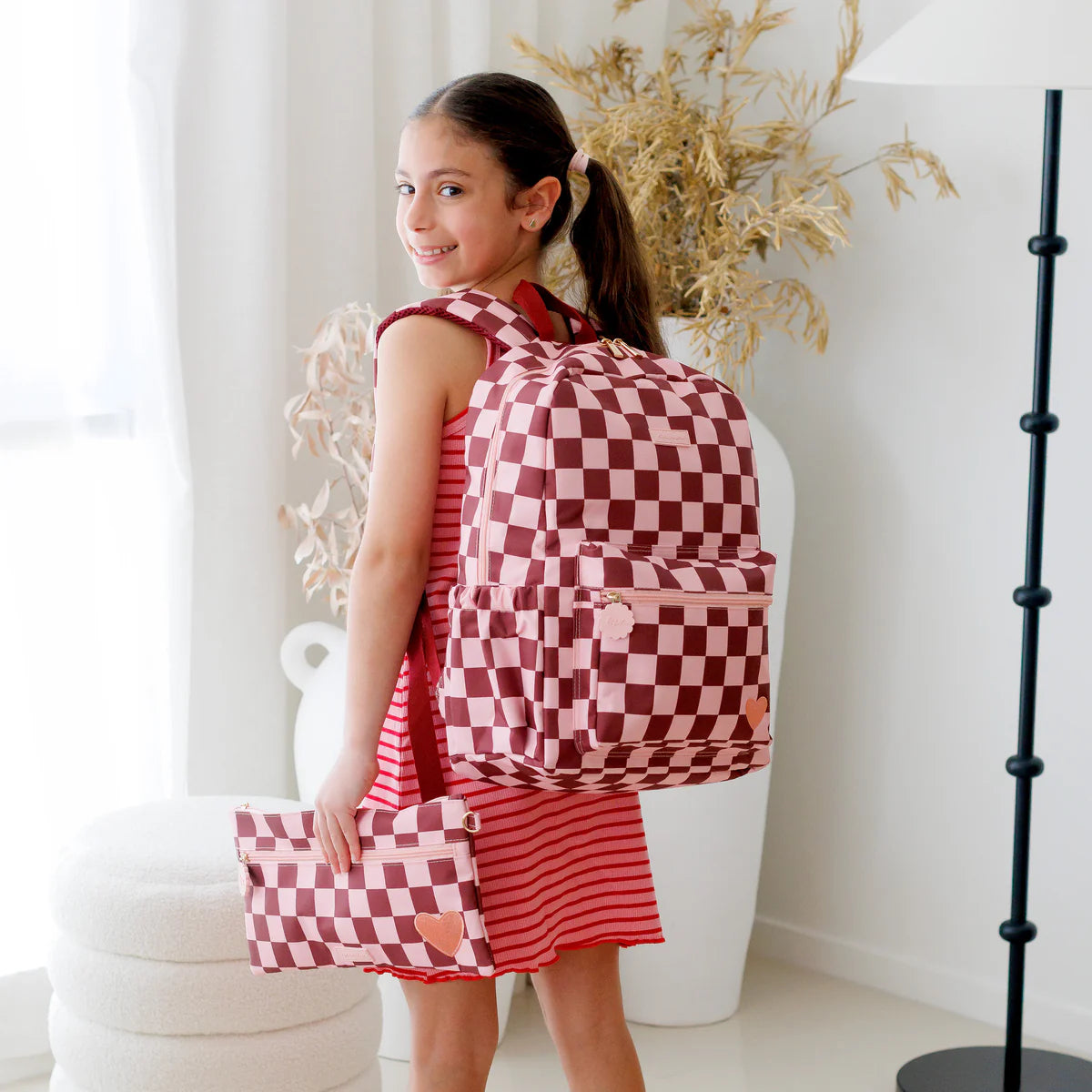 child wearing Fox & Fallow backpack for kids, perfect for school, daycare and everyday use. Spacious, practical and designed for little adventures. Personalisation of embroidery with name also available on bags in 2 placements. This print is cherry check with matching pencil case