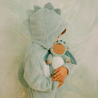 Child holding green dragon Cozy Dinkum plush doll