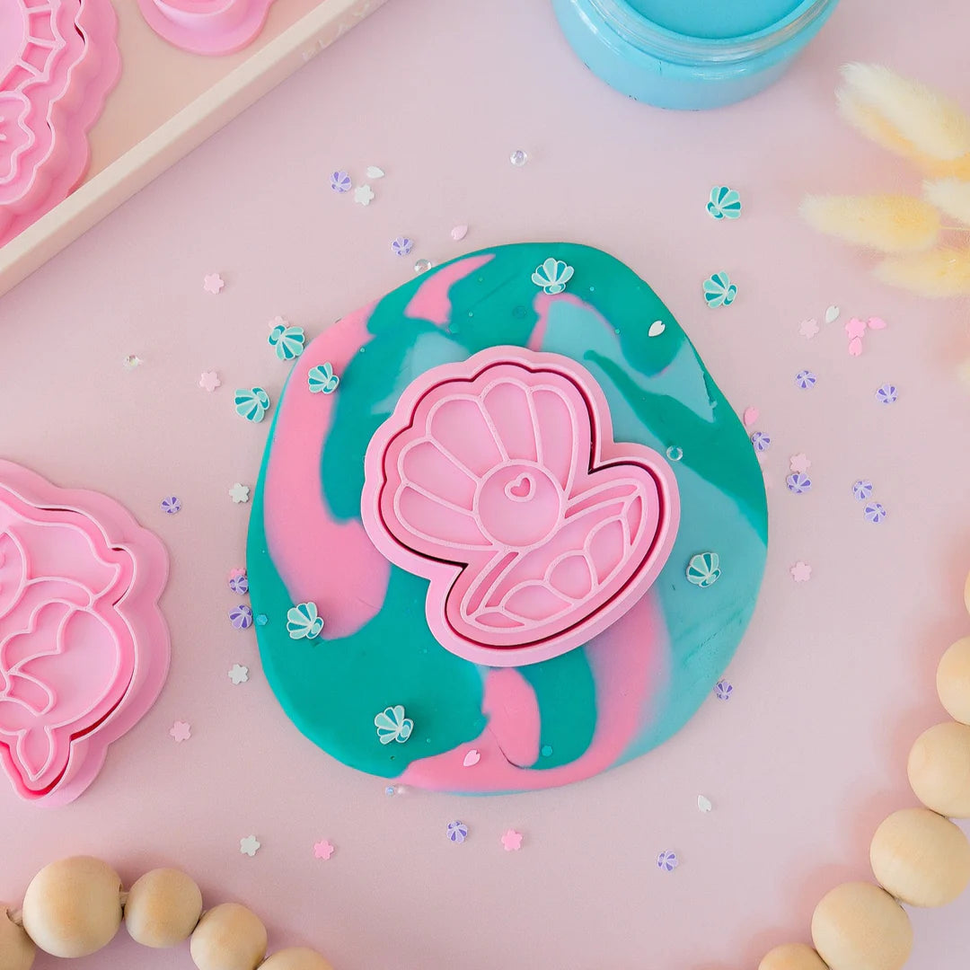 showing a styled image of playdough/clay stamp and cutter. Eco-friendly sensory play tool by brand playsense perfect for creative and imaginative play. can also be used for cookies and baking. pictured is pearl shell