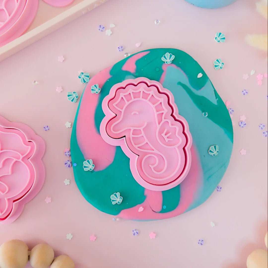 showing how to use image of playdough/clay stamp and cutter. Eco-friendly sensory play tool by brand playsense perfect for creative and imaginative play. can also be used for cookies and baking. pictured is baby seahorse