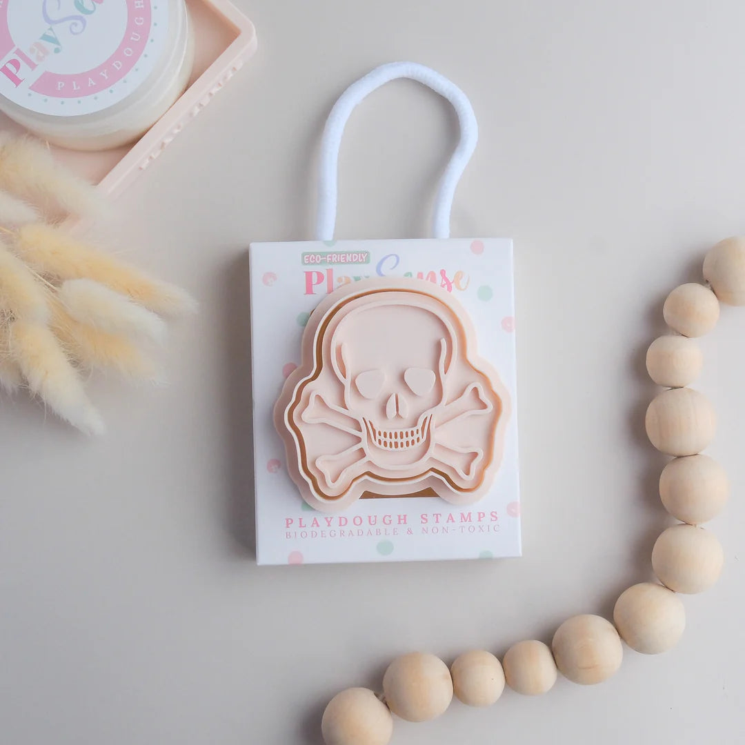 photoshoot image of playdough/clay stamp and cutter. Eco-friendly sensory play tool by brand playsense perfect for creative and imaginative play. can also be used for cookies and baking. pictured is skull and bones