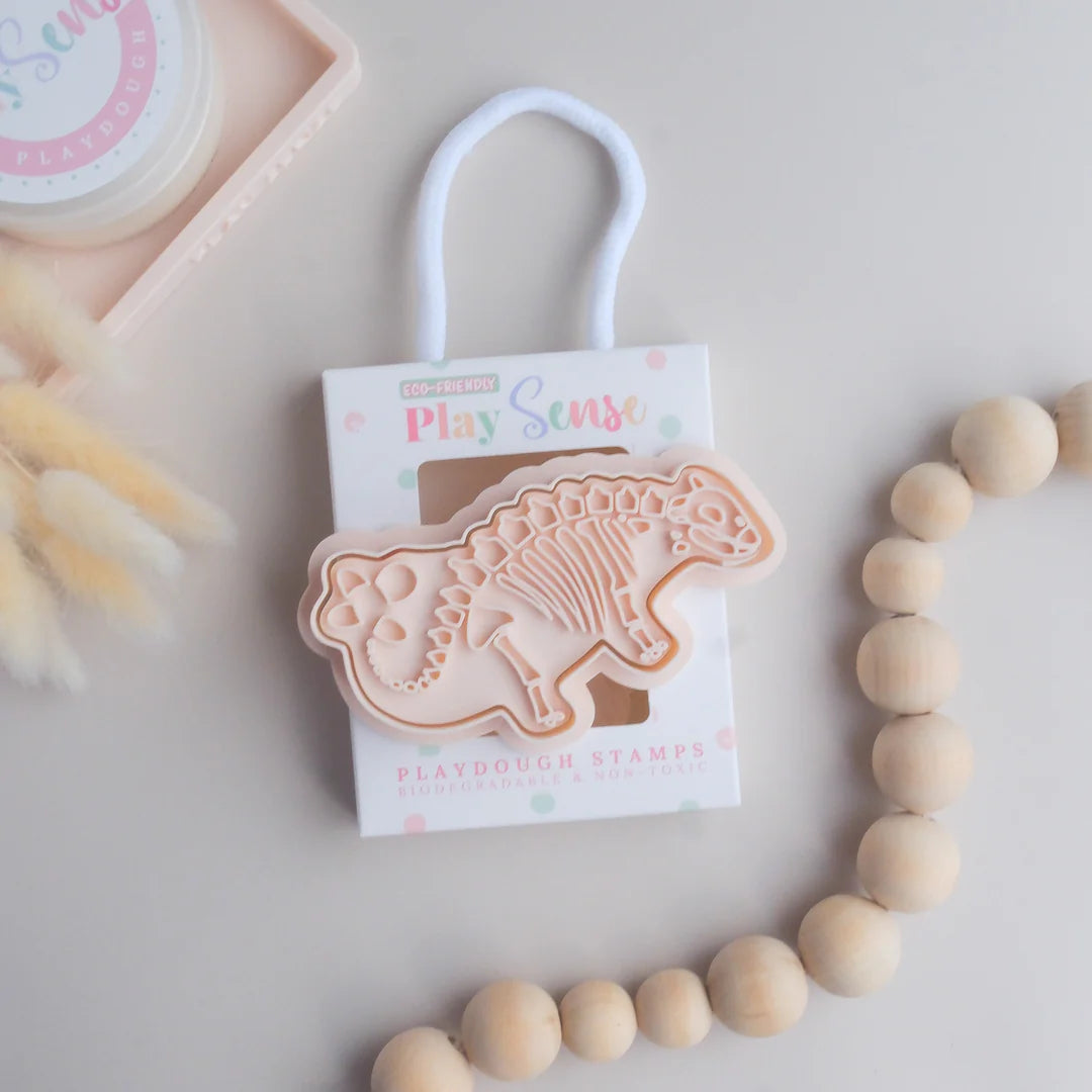photoshoot image of playdough/clay stamp and cutter. Eco-friendly sensory play tool by brand playsense perfect for creative and imaginative play. can also be used for cookies and baking. pictured is stegosaurus