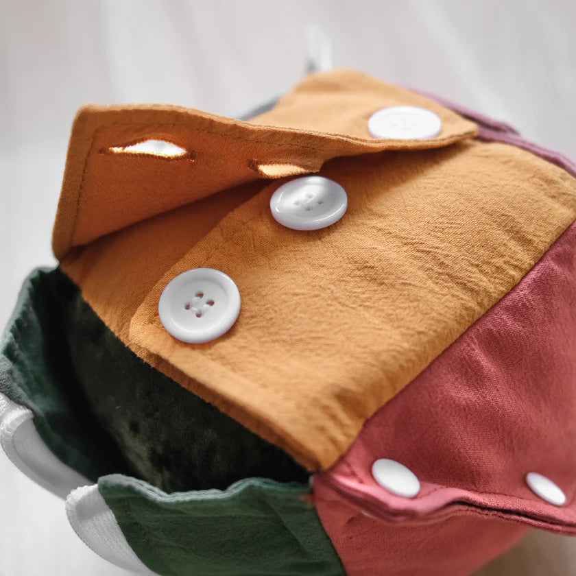 toddler using busy cube learning to zip and button fabric toy