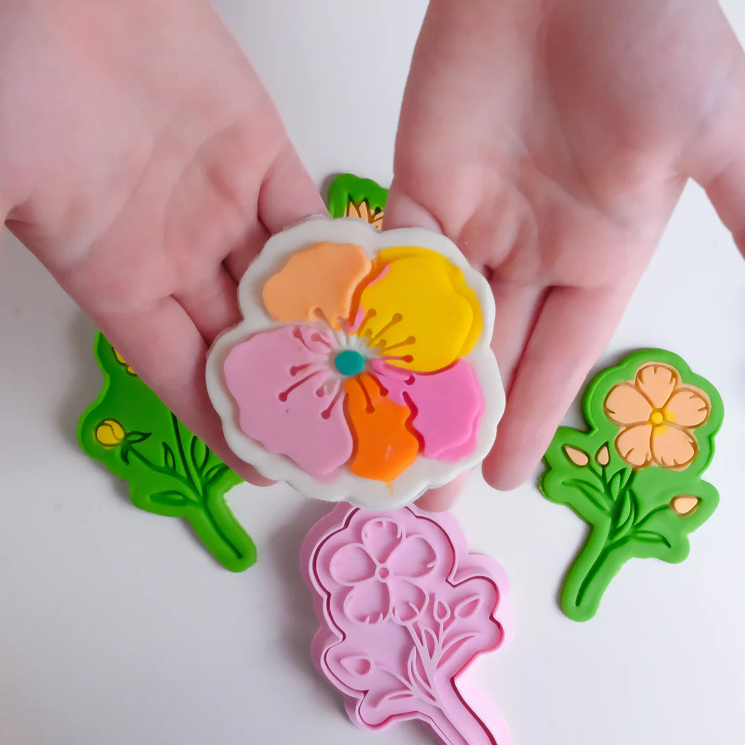 showing how to use image of playdough/clay stamp and cutter. Eco-friendly sensory play tool by brand playsense perfect for creative and imaginative play. can also be used for cookies and baking. pictured is poppy flower