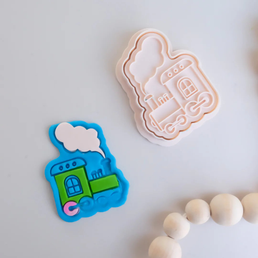 showing how to use image of playdough/clay stamp and cutter. Eco-friendly sensory play tool by brand playsense perfect for creative and imaginative play. can also be used for cookies and baking. pictured is steam train