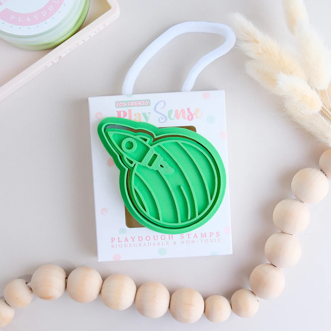 photoshoot image of playdough/clay stamp and cutter. Eco-friendly sensory play tool by brand playsense perfect for creative and imaginative play. can also be used for cookies and baking. pictured is a rocket blasting off a planet called blast off