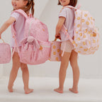 modelling wearing Fox & Fallow backpack for kids, perfect for school, daycare and everyday use. Spacious, practical and designed for little adventures. Personalisation of embroidery with name also available on bags in 2 placements. This print is daisy chain