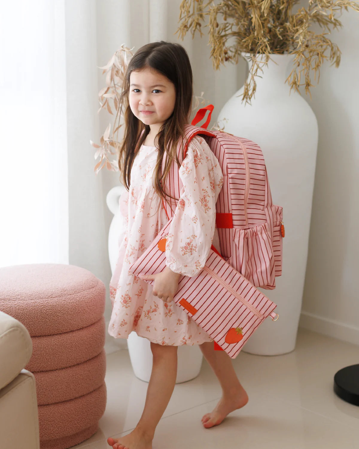 child wearing Fox & Fallow backpack for kids, perfect for school, daycare and everyday use. Spacious, practical and designed for little adventures. Personalisation of embroidery with name also available on bags in 2 placements. This print is strawberry stripe with matching pencil case