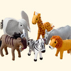 Set of toy animals including elephant, giraffe, zebra, lion, and zebra on a beige background