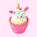 A cute felt cupcake decoration shaped like a unicorn, featuring mint green and white frosting, pink ears, a gold horn, and a pink scalloped cup with white polka dots, sitting on a small light blue saucer against a light lavender background.