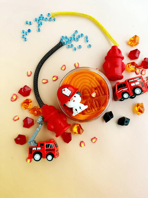 Top view of firefighter sensory dough jar with mini fire trucks, beads, and red sensory pieces for creative small world play