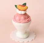 Handmade peach felt ice cream sundae with whipped cream and fruit topping for imaginative play kitchens
