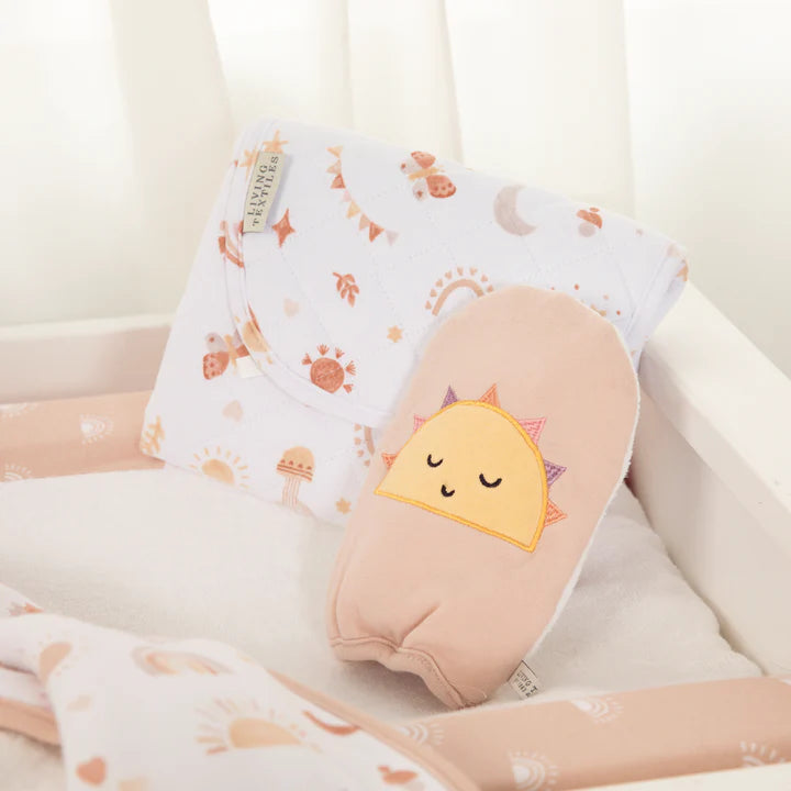 Baby bath mitt styled in nursery setting with matching peach and sun themed baby accessories