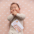 photoshoot of baby with milestone cards by lively living to track babies age and milestones. great for photos and theme is bohemian bliss. card pictured reads i played peek a boo today
