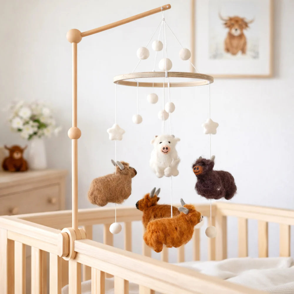 Highland Cow Felt Baby Mobile by Ganapati with handmade wool felt cows hanging from wooden frame