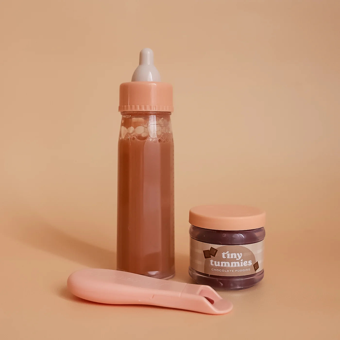 a closer look of the tiny chocolate box gift set outside the box, for pretend play with baby dolls. great for gifting and this pack includes chocolate milk, chocolate pudding and the magic spoon