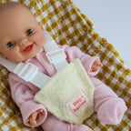 close up of mustard gingham Dolls Car Seat Capsule by tiny harlow with a doll inside