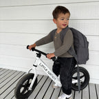 kid showing how to wear Corduroy kids backpack with front pocket, laptop sleeve, health label, name label, options to personalise a name with embroidery, spacious. perfect for school or travel. this colour is charcoal