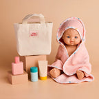 photoshoot of the tiny harlow bath accessory pack that comes with a bag, body lotion,baby doll towel, baby powder and bubble bath all for pretend play with dolls called tiny bath time