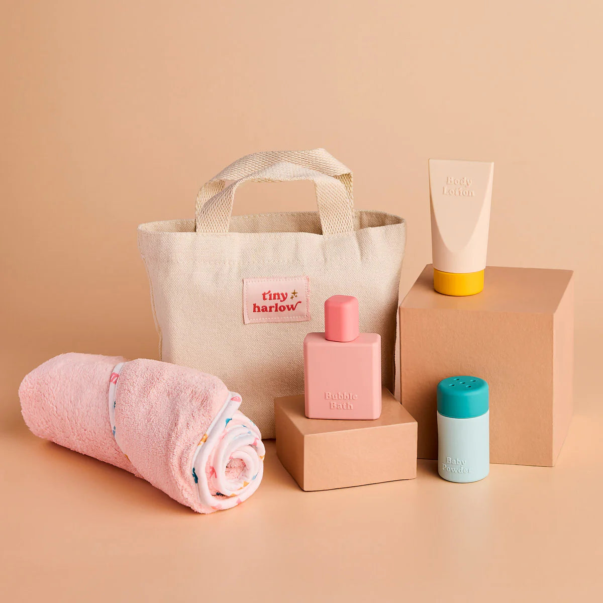 stock photo of the tiny harlow bath accessory pack that comes with a bag, body lotion,baby doll towel, baby powder and bubble bath all for pretend play with dolls called tiny bath time