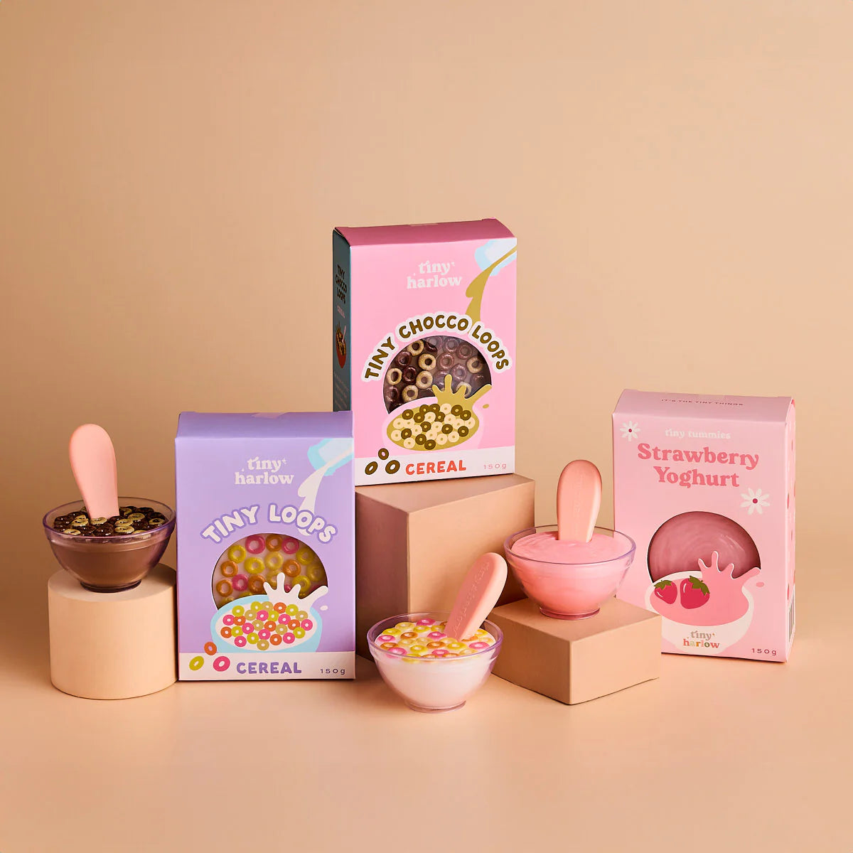 the tiny tummies cereal boxes and yoghurt box showcased. brand is tiny harlow and flavours are tiny loops cereal, tiny chocco loops cereal and strawberry yoghurt bowl