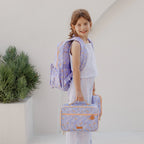 child side view wearing Fox & Fallow backpack for kids, perfect for school, daycare and everyday use. Spacious, practical and designed for little adventures. Personalisation of embroidery with name also available on bags in 2 placements. This print is juniper - lilac purple with leaves