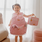 young girl showing Fox & Fallow backpack for kids, perfect for school, daycare and everyday use. Spacious, practical and designed for little adventures. Personalisation of embroidery with name also available on bags in 2 placements. This print is dusty roses
with matching lunch bag