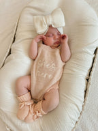 Blossom and Pear baby girl announcement outfit with pink She’s Here knit romper set