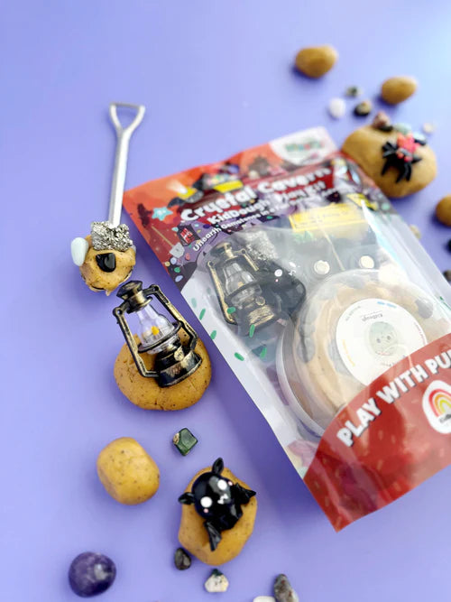 Dig and discover playdough kit with rocks, crystals, toy mining cart and accessories displayed on pastel background for creative sensory exploration