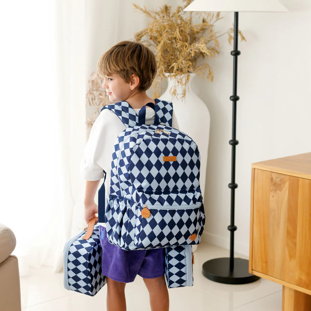 child wearing Fox & Fallow backpack for kids, perfect for school, daycare and everyday use. Spacious, practical and designed for little adventures. Personalisation of embroidery with name also available on bags in 2 placements. This print is blue diamonds