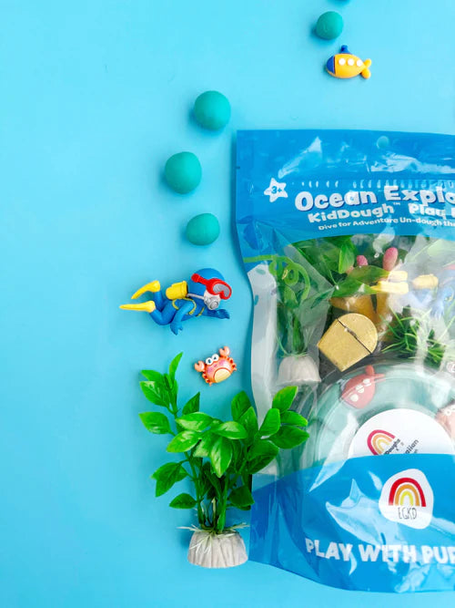 Ocean Explorer KidDough pouch with sea creature charms, seaweed, coral and sensory dough arranged for creative storytelling and fine motor development