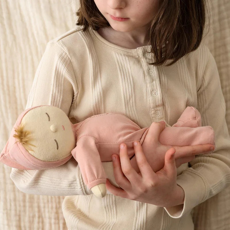 Child holding Moppet Dozy Dinkum doll soft baby toy
