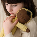 Child holding Mini Dozy Dinkum doll by Olli Ella