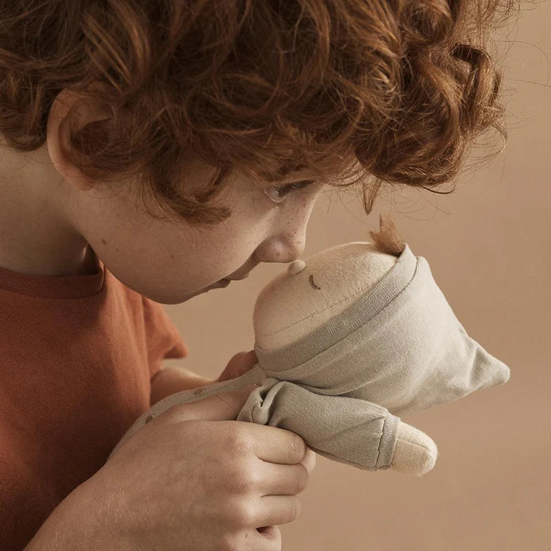 Child holding Pickle Dozy Dinkum doll soft baby toy