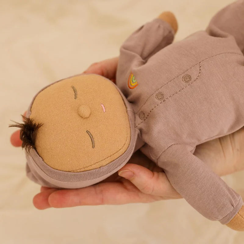 Child holding Pip Dozy Dinkum doll soft baby toy