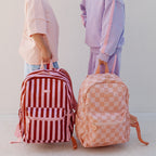 photoshoot of Fox & Fallow backpack for kids, perfect for school, daycare and everyday use. Spacious, practical and designed for little adventures. Personalisation of embroidery with name also available on bags in 2 placements. This print is peach checks and burgundy stripe