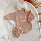 She’s Here long sleeve newborn knit romper bundle by Blossom and Pear with matching booties and topknot headband