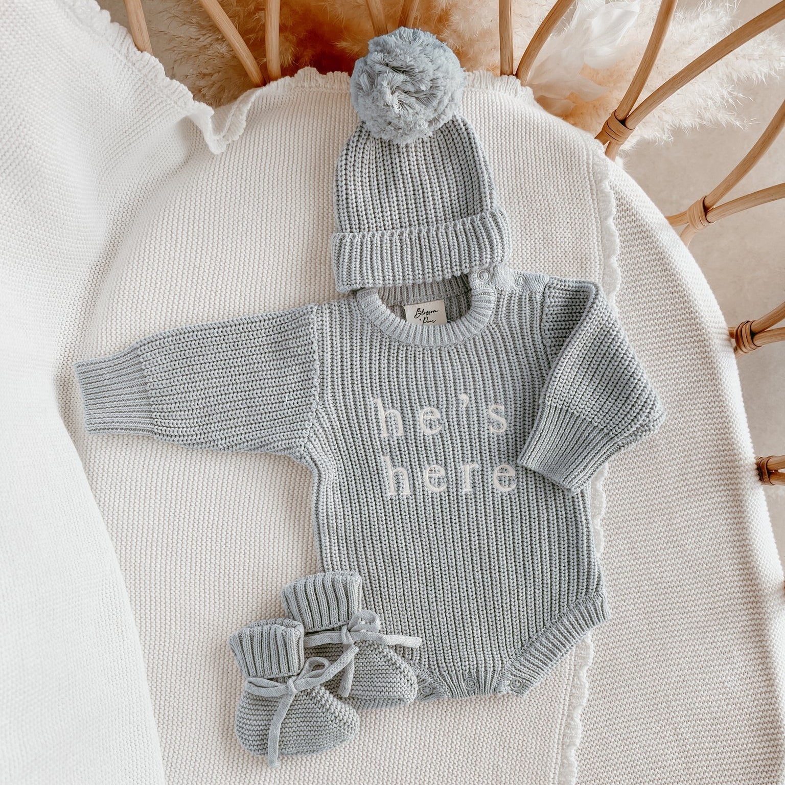 He’s Here long sleeve newborn knit romper bundle by Blossom and Pear with matching booties and pom pom beanie
