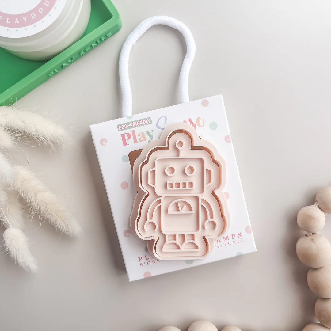 photoshoot image of playdough/clay stamp and cutter. Eco-friendly sensory play tool by brand playsense perfect for creative and imaginative play. can also be used for cookies and baking. pictured is robot