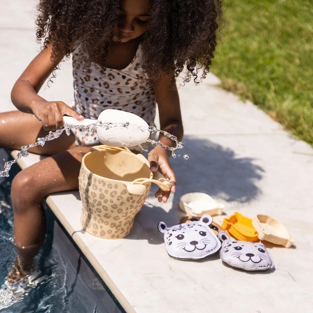 Child playing beach bucket swim essentials