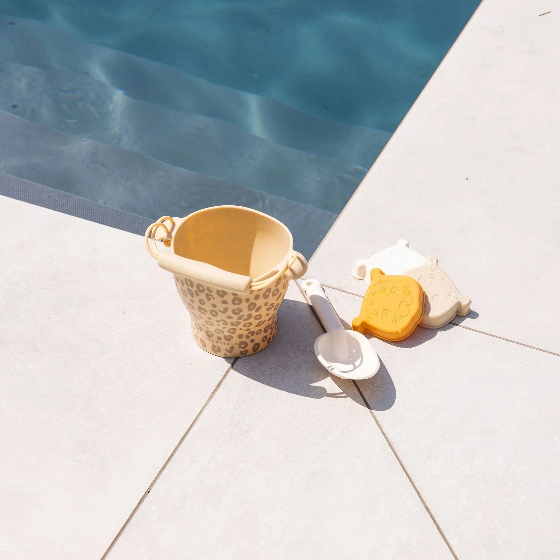 Yellow leopard and toys by a poolside swim essentials