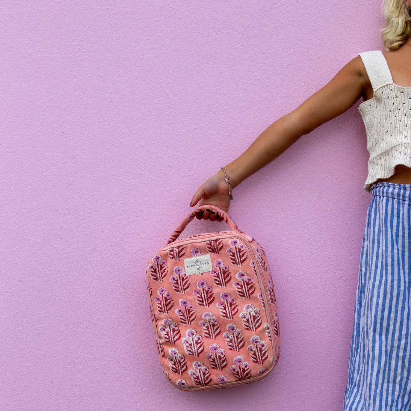 floral print lunch bag for kids with durable canvas exterior against pink wall child holding