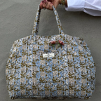 quilted duffle style bag with floral pattern and strap