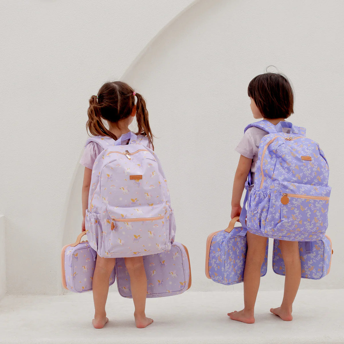 modelling how to wear Fox & Fallow backpack for kids, perfect for school, daycare and everyday use. Spacious, practical and designed for little adventures. Personalisation of embroidery with name also available on bags in 2 placements. This print is unicorns and juniper
