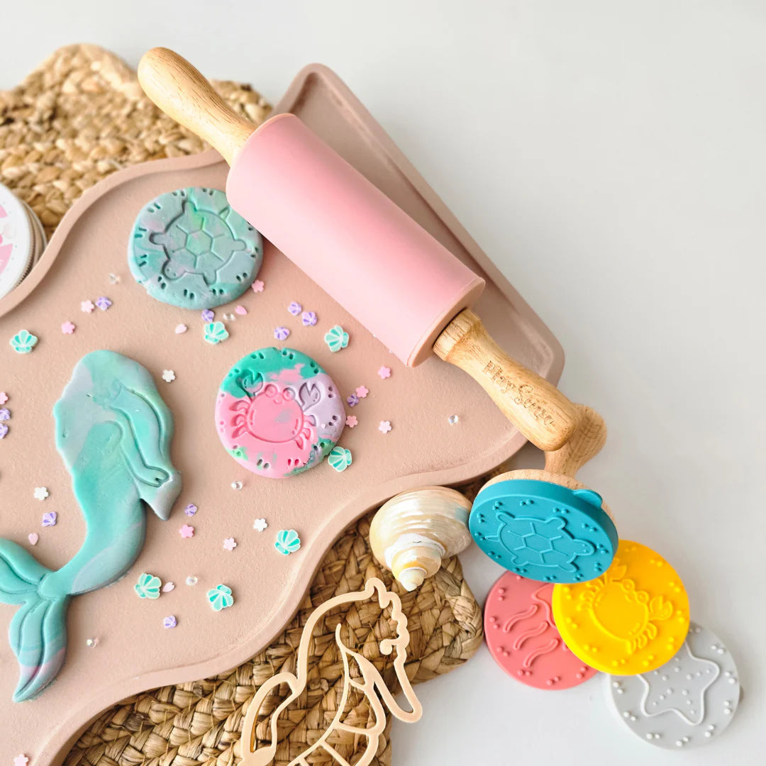 showing how to use brand Playsense Dough Roller, the perfect tool for both playdough fun and beginner baking. pictured is pink 