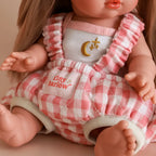 close up of photoshoot of baby dolls carrier made by tiny harlow with baby inside. good for pretend play, the print is pink gingham