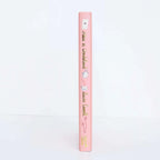 spine of Alice in Wonderland collector’s edition hardback book with blush pink illustrated cover, gold foil lettering and sprayed heart cards page edges by Lewis Carroll. wordsworth collectors limited edition