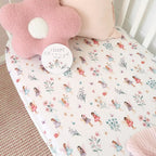 Fairy Garden organic fitted cot sheet styled on a nursery cot with soft pink bedding creating a magical fairy themed baby room
