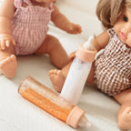 photoshoot of the tiny harlow branded magic milk and juice bottles made for baby dolls pretend play. liquid disappears and is a lot of fun